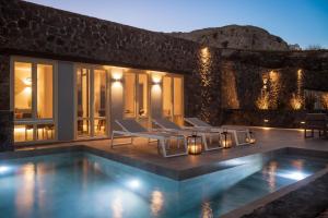 a villa with a swimming pool at night at Almarossa Luxury Villas in Vourvoulos