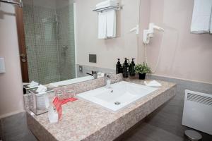 a bathroom with a sink and a mirror at Ramada Plaza Craiova in Craiova