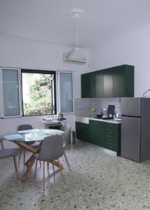 a kitchen with green cabinets and a table and chairs at Magical villa western peloponnese by MPS in Pyrgos