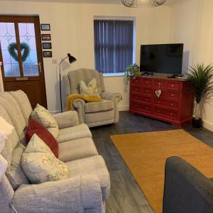 een woonkamer met een bank en een tv bij Ouse House in Swinefleet