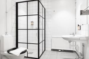 a black and white bathroom with a toilet and a sink at Gibsons Hotell in Jonsered