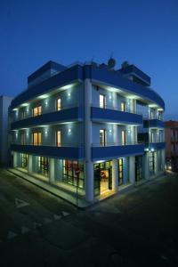 un grand bâtiment bleu avec ses lumières allumées dans l'établissement Blu Residence - Hotel nel Salento, à Casarano
