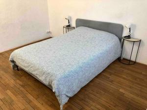 un letto in una camera da letto con due lampade su due tavoli di 40m² totalement rénovés belle vue dégagée (102) a Villeneuve-Saint-Georges