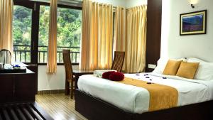a bedroom with a bed and a large window at The Cascade Munnar in Anachal