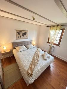 a bedroom with a bed and two lamps and a window at Le Cocon du Vignoble - Free Wifi - Netflix in Turckheim