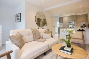 The Kingswood Place - Modern 2BDR with Terrace في West Dulwich: غرفة معيشة مع أريكة بيضاء وطاولة