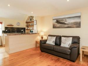 a living room with a couch and a kitchen at Oak Tree Cottage With Indoor Pool In Devon in Broadwoodkelly