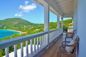 a porch with a view of the ocean and mountains at Stunning Villa overlooking Friendship Bay Beach in Union