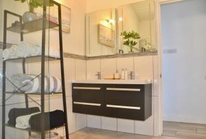 a bathroom with a sink and a shelf with towels at Stunning Villa overlooking Friendship Bay Beach in Union