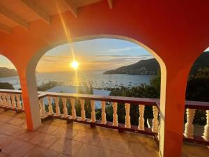 a view from the balcony of a house with the sunset at Immaculate 3 Bed Villa Overlooking Admiralty Bay in Union