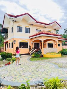 Une petite fille debout devant une maison dans l'établissement Chateau La Princesa with cozy terrace, à Puerto Princesa