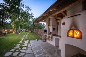 un horno de pizza al aire libre en una casa con patio en Casuta cu Mar de la Joyard, en Porumbacu de Sus