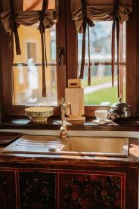 encimera de cocina con fregadero y ventana en Casuta cu Mar de la Joyard en Porumbacu de Sus