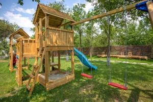 a wooden playground with a slide and swings at Casuta cu Mar de la Joyard in Porumbacu de Sus