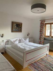 a bedroom with a white bed and a window at Haus Kaiser in Rottach-Egern