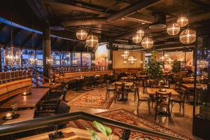 a restaurant with wooden tables and chairs and lights at Break Sokos Hotel Tahko in Tahkovuori