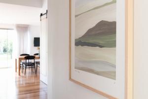 een schilderij aan een muur in een woonkamer bij Villa Gwen: Character Home Moments from the City in Invermay
