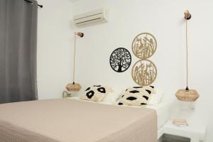a bedroom with a bed with black and white pillows at Aegean White Aparts in Naxos Chora