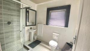 a bathroom with a toilet and a sink and a shower at Ubuhle Guest House in Standerton