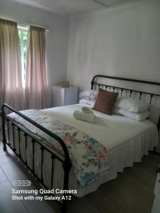 a bedroom with a large bed with white sheets and pillows at Secret guest house in Pietermaritzburg