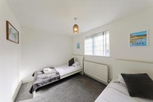1 dormitorio con 2 camas y ventana en Hythe Townhouse Retreat en Kent