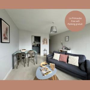 un soggiorno con divano blu e tavolo di Le Primaubois - 2 chambres & parking - Centre La Primaube a Flavin