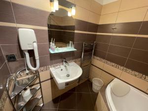 a bathroom with a sink and a toilet and a mirror at Hotel Pod Zámkem in Boskovice