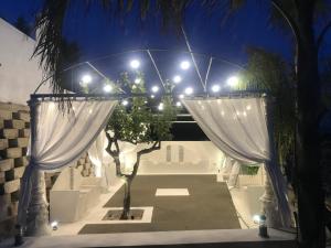 una cerimonia all'aperto con tende e luci bianche di Villa Corbera Palmaris a Marina di Palma