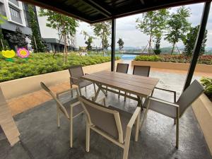 a wooden table and chairs on a patio at Executive Escapes [The Netizen Cheras] 3房公寓 #MRT in Cheras