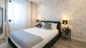 馬托西紐什的住宿－Skyline Lofts by LovelyStay，一间卧室配有一张带白色床单的大床