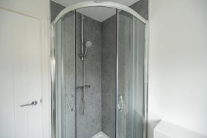 a shower with a glass door in a bathroom at Woodham House By Horizon Stays in Stockton-on-Tees