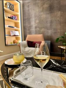 una copa de vino blanco sentada en una mesa en Villa Eulalie B&B Guest House nestled in the Champagne area, en Bligny