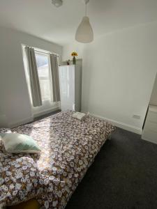 sypialnia z łóżkiem z kołdrą i oknem w obiekcie The Sunflower En-suite Room w mieście Plymouth