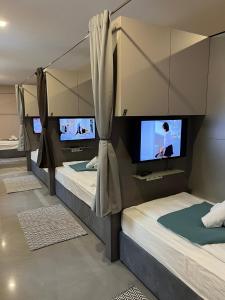 two bunk beds in a room with three televisions at New Central Apartments Westbahnhof in Vienna