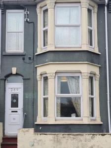a gray house with a white door and windows at Double Rooms with shared bathroom in Gillingham