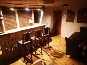 un bar en una habitación con sillas y mesa en Sodyba Žuvalsa, 