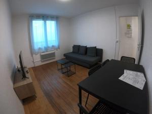 ein Wohnzimmer mit einem Sofa und einem Tisch in der Unterkunft 40m² totalement rénovés belle vue dégagée (301) in Villeneuve-Saint-Georges