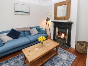 a living room with a blue couch and a fireplace at Fleming House in Cowes