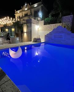 una piscina con illuminazione blu di fronte a una casa di Villa Corbera Palmaris a Marina di Palma