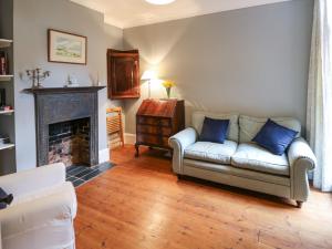 a living room with a couch and a fireplace at Fleming House in Cowes