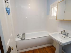 a white bathroom with a tub and a sink at Fleming House in Cowes