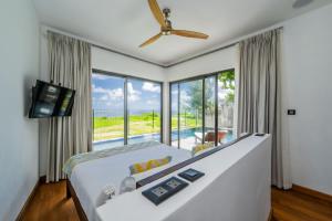 a bedroom with a large bed and a large window at Stunning Beachfront Villa for a Perfect Getaway in Riambel