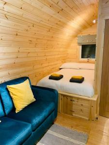 Habitación con cama y sofá en una cabaña en The Pod Over By en Kilmichael Glassary