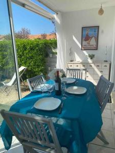 uma mesa com uma toalha de mesa azul num pátio em Les Baigneuses Pontaillac T2 jardin piscine em Vaux-sur-Mer