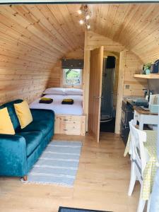 Habitación con cama y sofá en una casa pequeña en The Pod Over By en Kilmichael Glassary