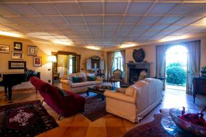 un soggiorno con divani e pianoforte di Villa Antico Toscano a Polistena