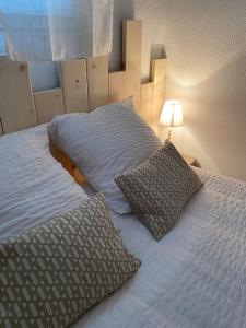 um quarto com uma cama com duas almofadas em Les Baigneuses Pontaillac T2 jardin piscine em Vaux-sur-Mer