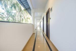 FabHotel Don Hill Beach Resort في Goa: مدخل مبنى مع نافذة كبيرة