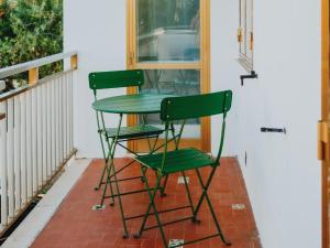 due sedie verdi sedute accanto a un tavolo su un portico di SE046 - Marotta, nuovo bilocale fronte mare a Marotta