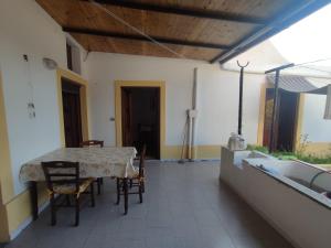a dining room with a table and chairs and an umbrella at Casa Amena con ampio terrazzo e giardino in Lipari
